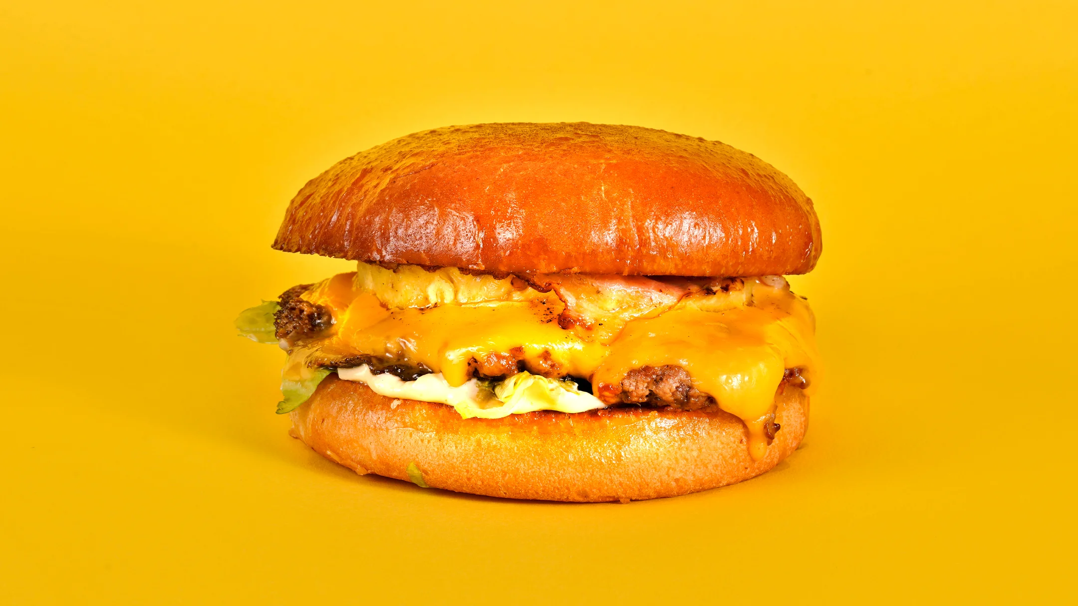 Projeto SMASH VS THREAT da Nhdesign: Hambúrguer Sneaky Smash com ovo e queijo sobre fundo amarelo