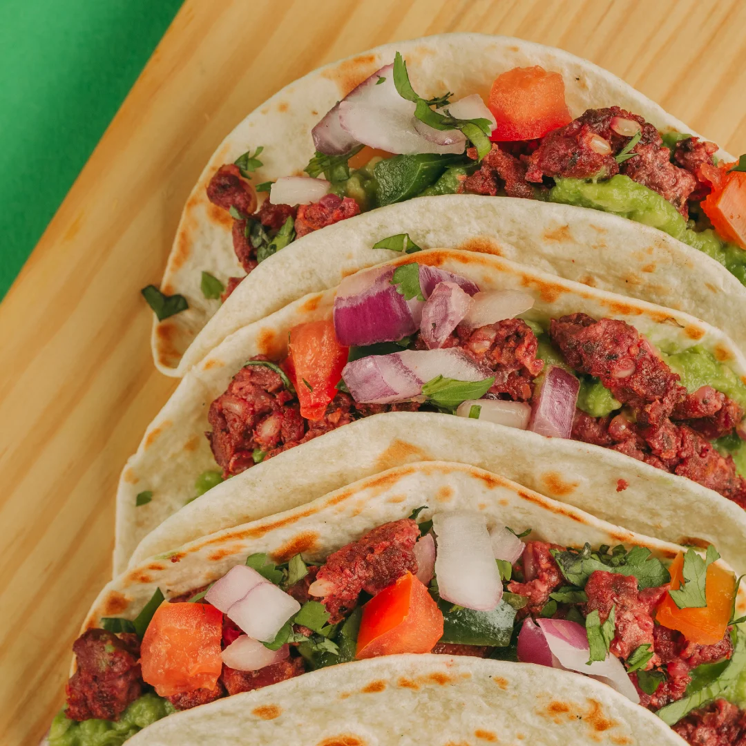 Projeto SMASH VS THREAT da Nhdesign: Tacos recheados com carne, tomate e alface servidos em prato de madeira