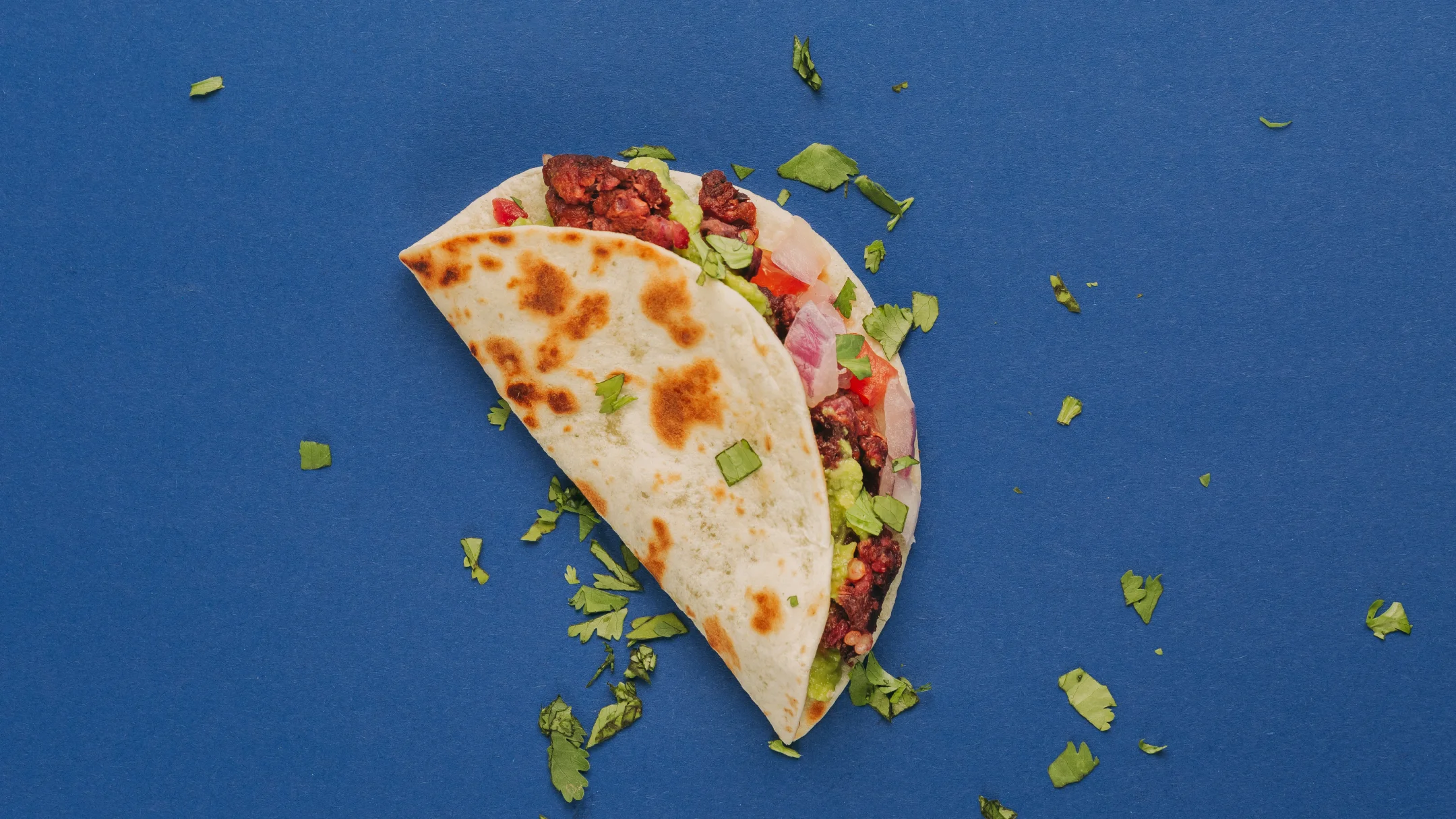 Projeto SMASH VS THREAT da Nhdesign: Taco individual servido em fundo azul com guarnição verde