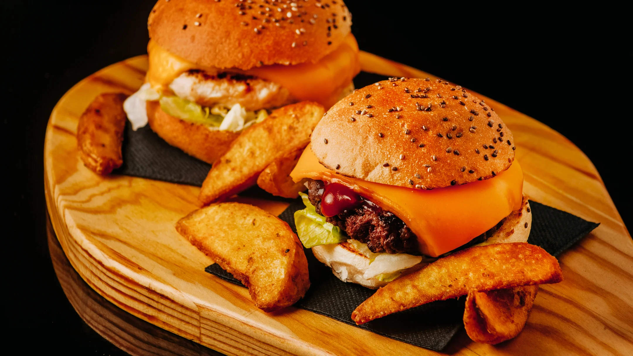 Projeto DANS da Nhdesign: hambúrgueres DANS servidos em tábua de madeira com batatas fritas