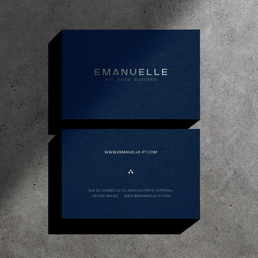 Projeto Emanuelle da Nhdesign: Frente e verso do cartão de visita sobre fundo de cimento.