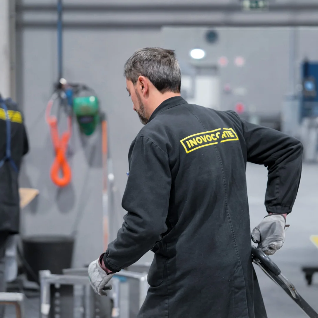 Projeto Inovocorte da Nhdesign: Operador da Inovocorte de costas com uniforme numa área industrial