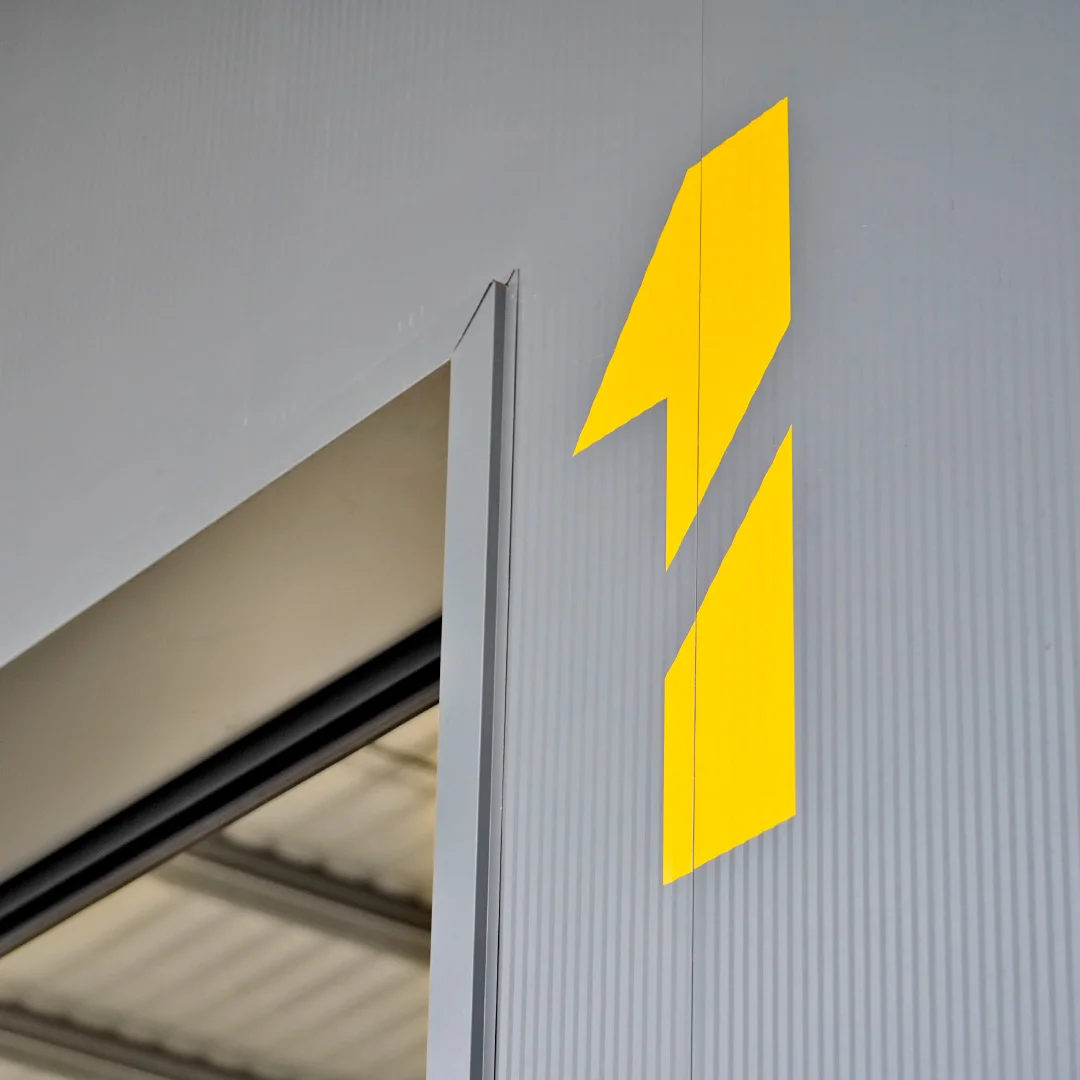 Projeto Inovocorte da Nhdesign: Logótipo amarelo da Inovocorte aplicado na parede exterior do edifício