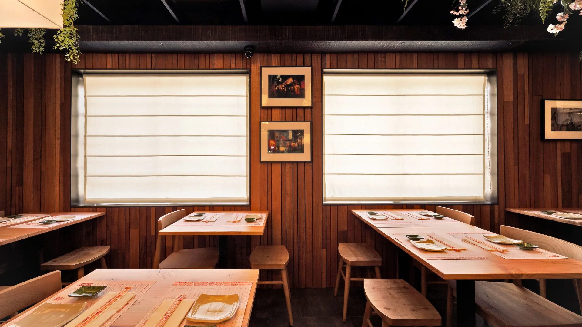 Projeto Izakaya Matsuri da Nhdesign: Interior de um restaurante com mesas e cadeiras arrumadas em frente a uma grande janela.