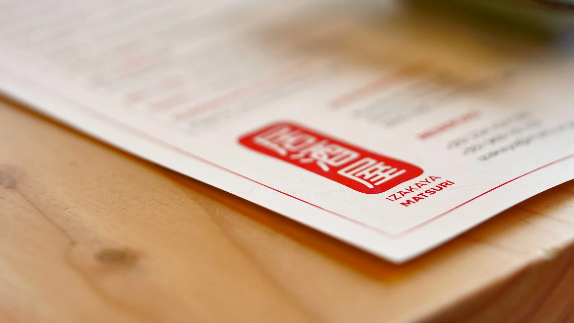 Projeto Izakaya Matsuri da Nhdesign: Logótipo vermelho e branco sobre um individual em close-up.