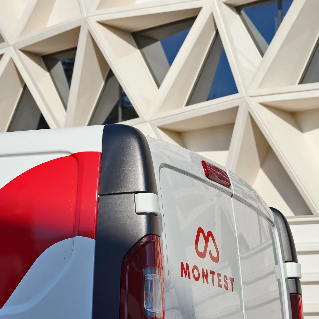 Projeto Montest da Nhdesign: Viatura da Montest com logótipo aplicado em frente a edifício moderno.