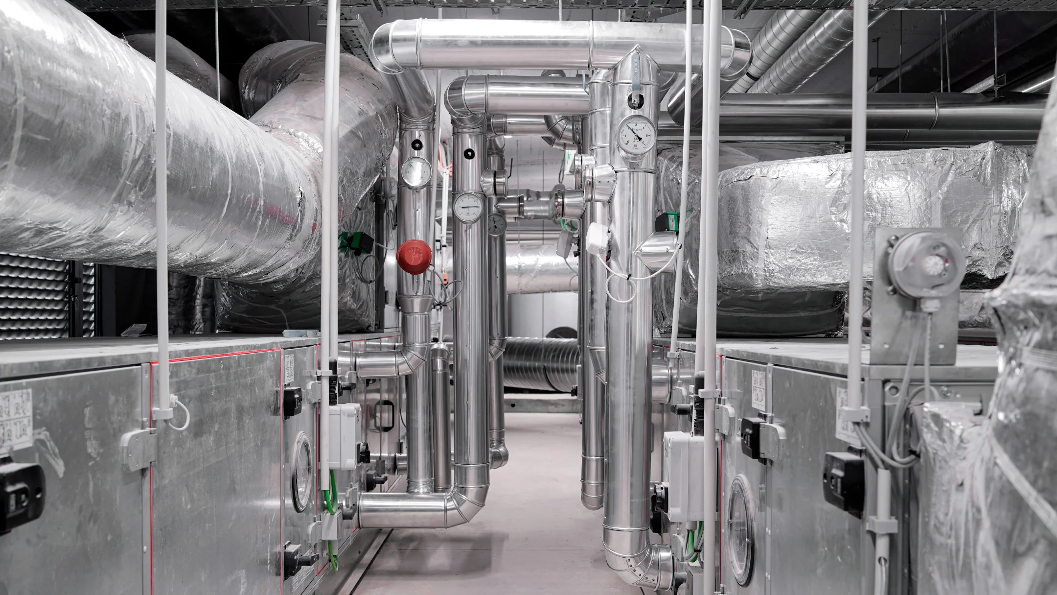 Projeto NB Klima da Nhdesign: Interior de instalações industriais da NB Klima com máquinas e tubagens
