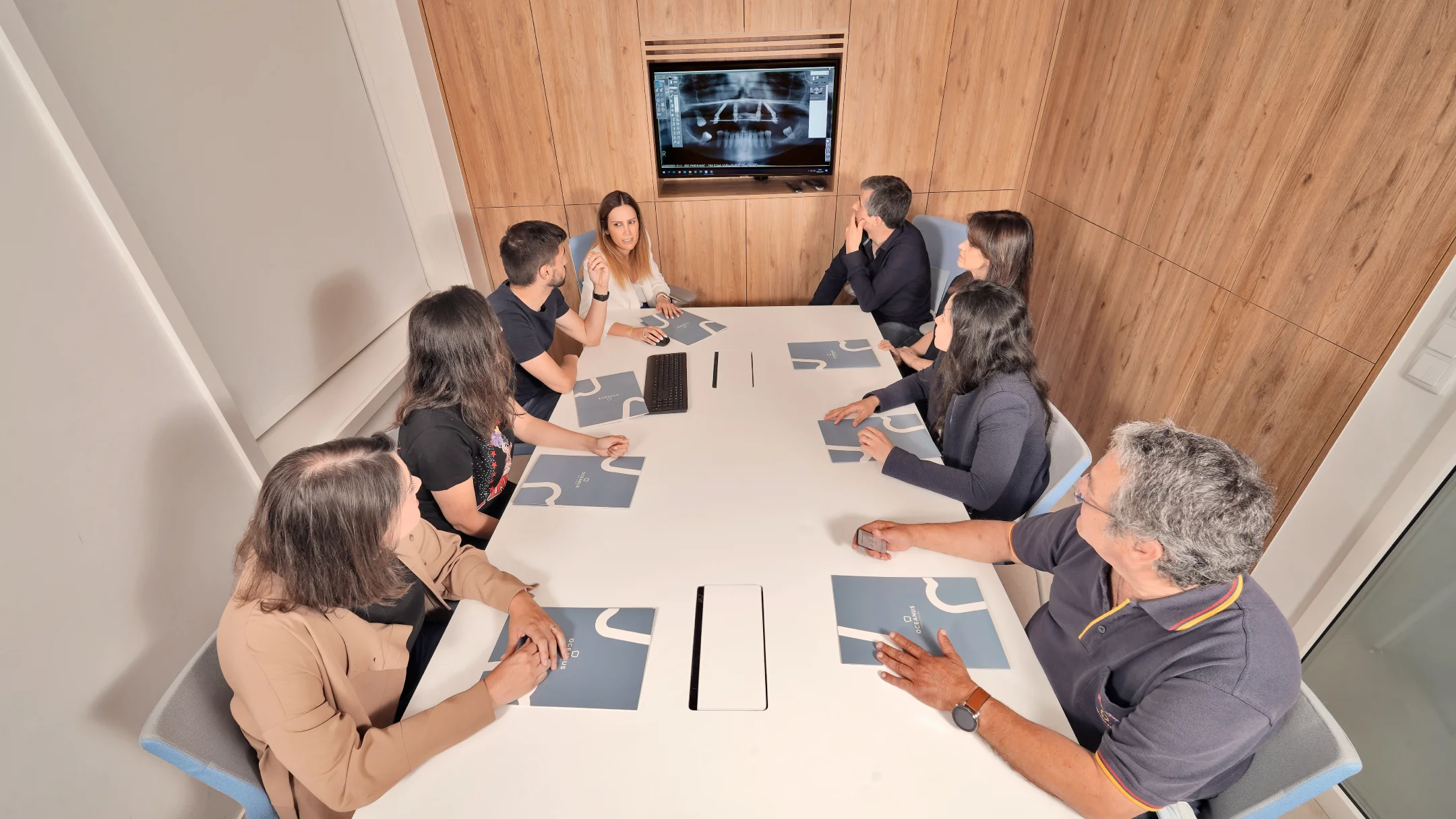 Projeto OCEANUS da Nhdesign: Equipa Oceanus Oral Center em reunião de trabalho numa sala moderna