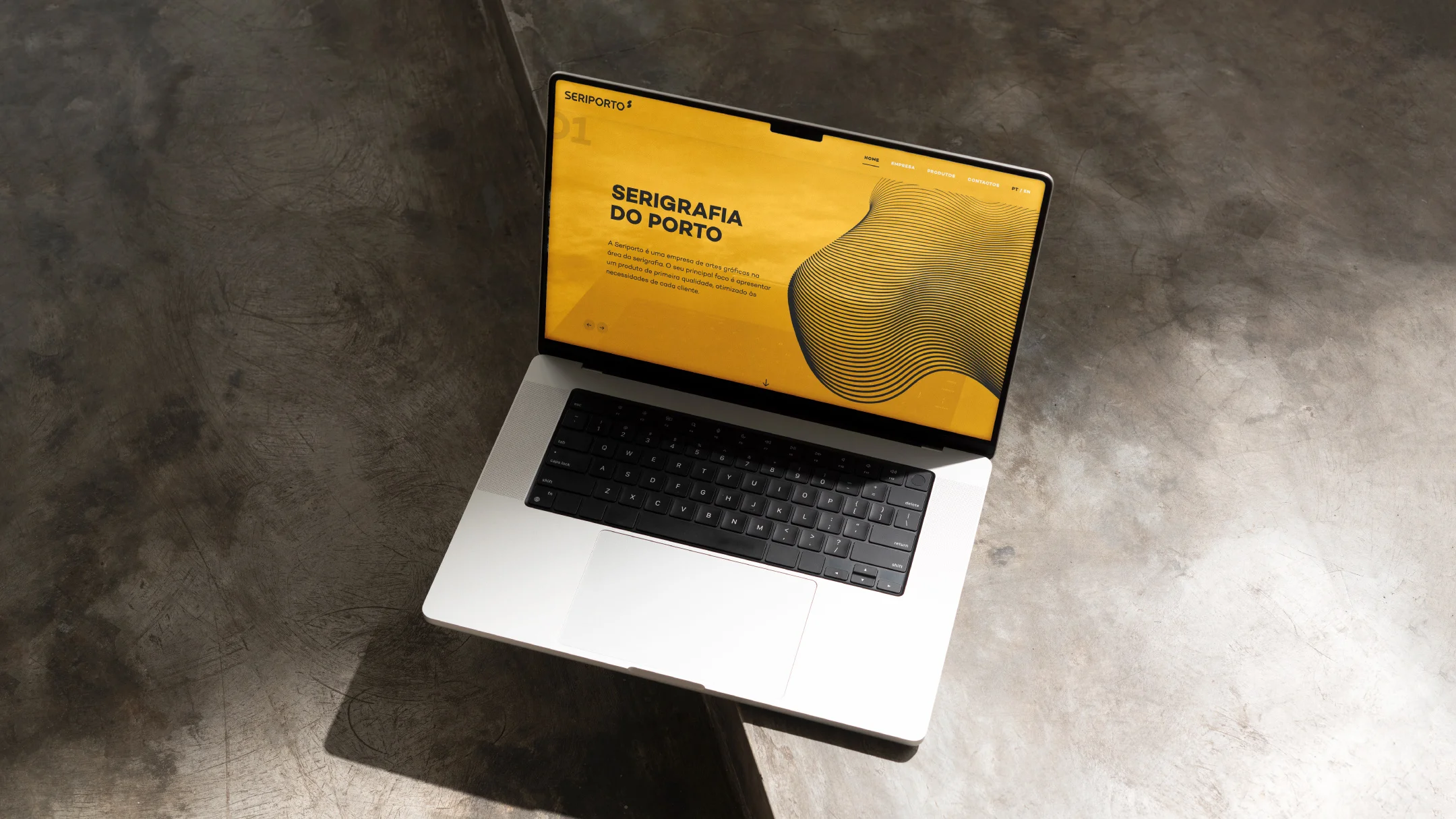 Projeto Seriporto da Nhdesign: Website da Seriporto apresentado em computador portátil com fundo de betão.