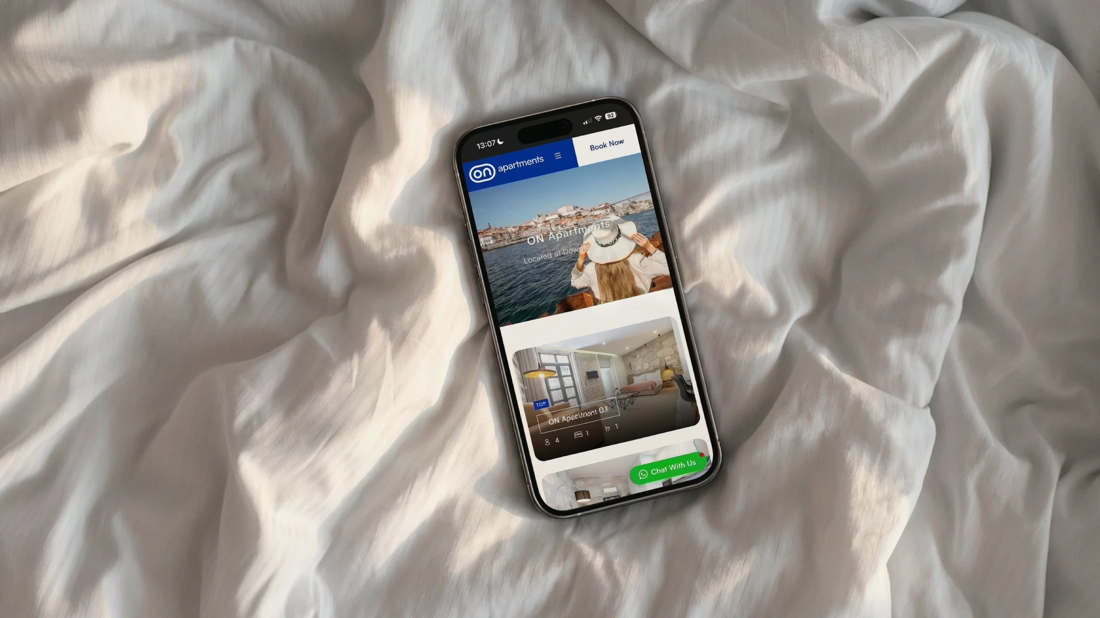 Projeto ON Apartments da Nhdesign: Telemóvel com o site ON em contexto lifestyle, a comunicar conforto e experiência de estadia